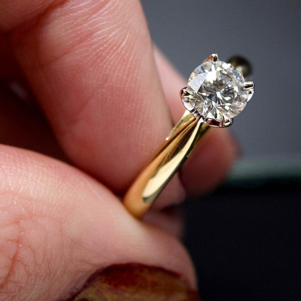 18ct Gold Petal Solitaire Diamond Engagement Ring in hand, sold at Nouveau Jewellers in Manchester