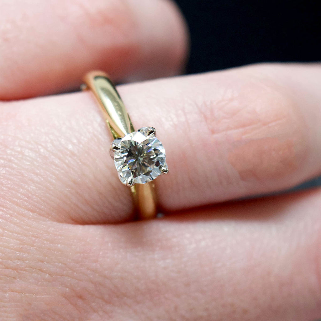18ct Gold Petal Solitaire Diamond Engagement Ring close up on finger, sold at Nouveau Jewellers in Manchester