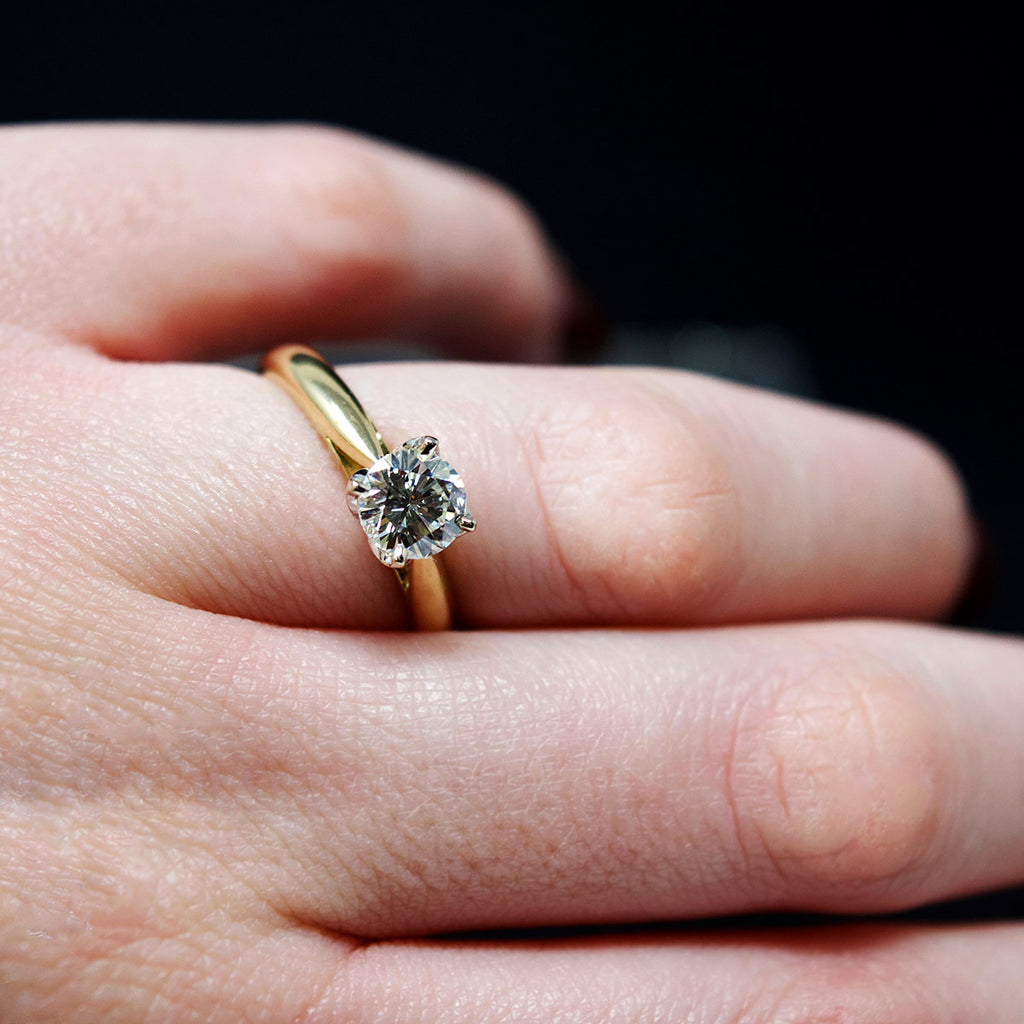 18ct Gold Petal Solitaire Diamond Engagement Ring on finger side profile, sold at Nouveau Jewellers in Manchester