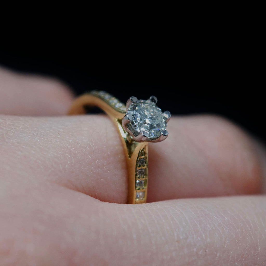 18ct Yellow Gold Solitaire Diamond Engagement Ring with Diamond Shoulders on finger, sold at Nouveau Jewellers in Manchester