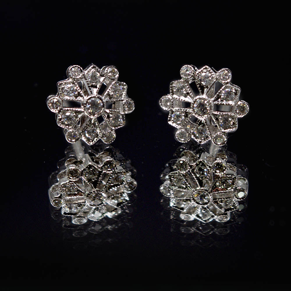 18ct White Gold Diamond Snowflake Art Deco Earrings on reflective surface, sold at Nouveau Jewellers in Manchester